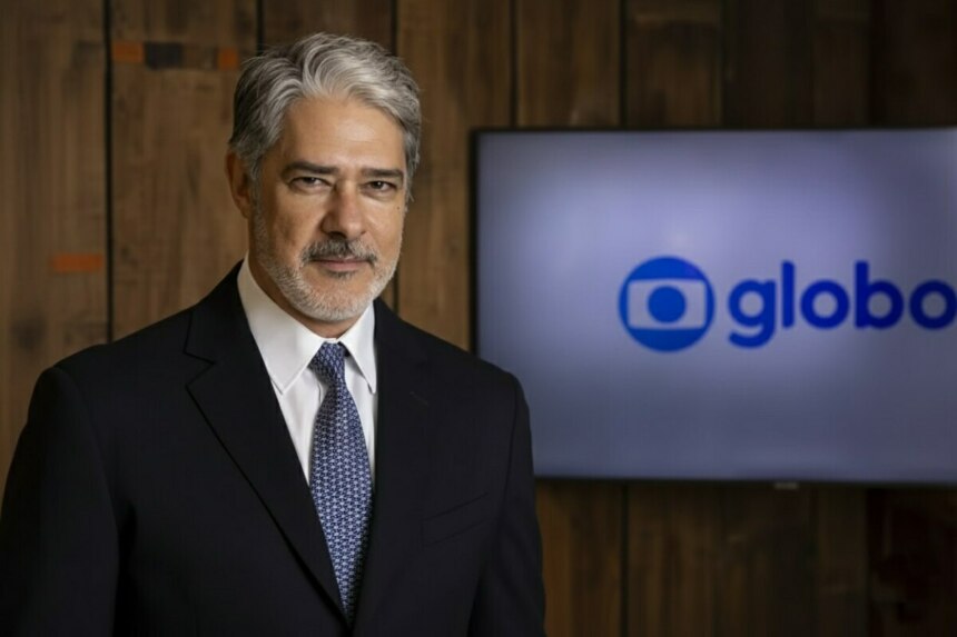 William Bonner sério em frente ao telão com o logo da TV Globo