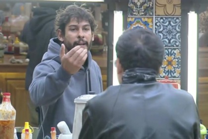 Shia (em pé) e Dudu Camargo (sentado) em trecho de treta na cozinha de A Fazenda