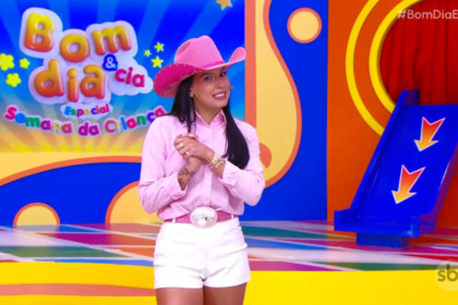 Ana Castela de chapéu rosa no cenário colorido do Bom Dia e CIA