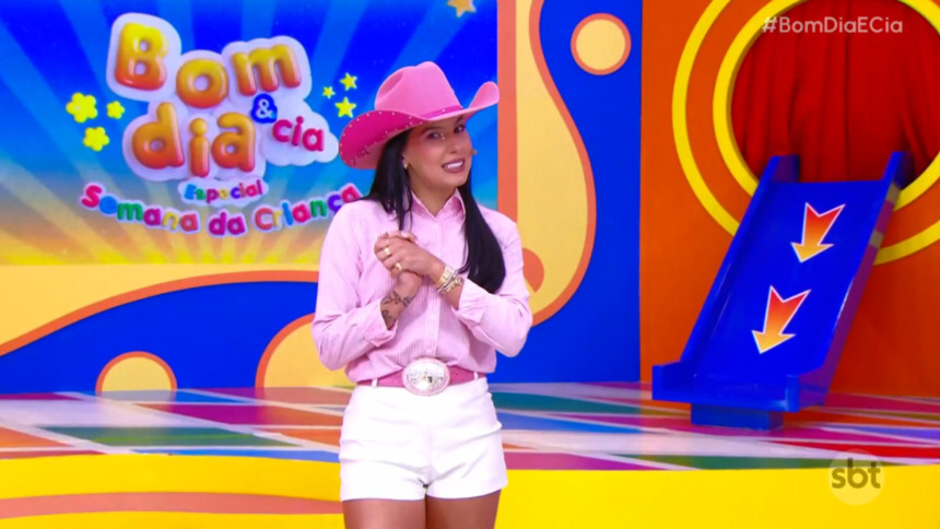 Ana Castela de chapéu rosa no cenário colorido do Bom Dia e CIA