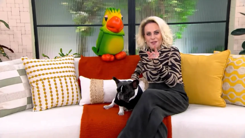Ana Maria Braga ao lado do Louro Mané e de um cachorrinho, sentados no sofá do cenário do Mais Você