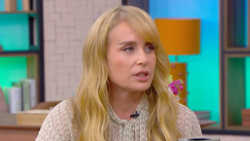 A apresentadora Angélica em uma entrevista no programa Mais Você. Ela está de cabelos loiros longos com franja e veste uma blusa bege rendada.