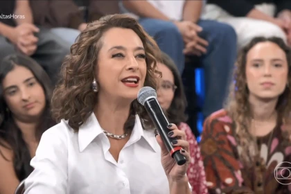 Catia Fonseca segura microfone no cenário do Altas Horas