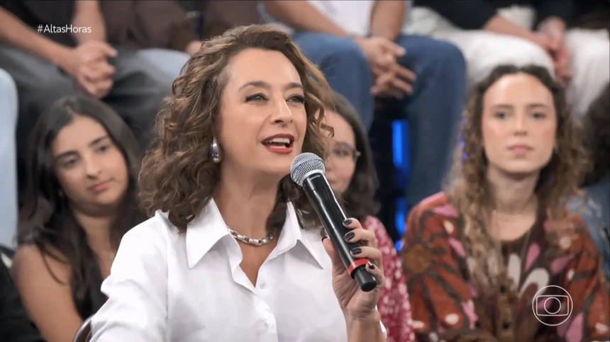 Catia Fonseca segura microfone no cenário do Altas Horas