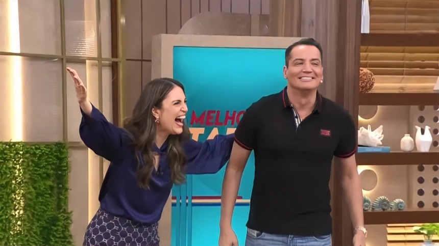 Chris Flores abre os braços e sorrir ao lado de Leo Dias no cenário do Melhor da Tarde