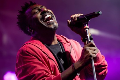 Dodô do Pixote com um microfone na mão em trecho de show