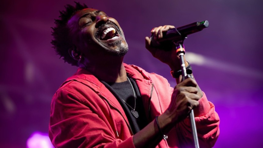 Dodô do Pixote com um microfone na mão em trecho de show