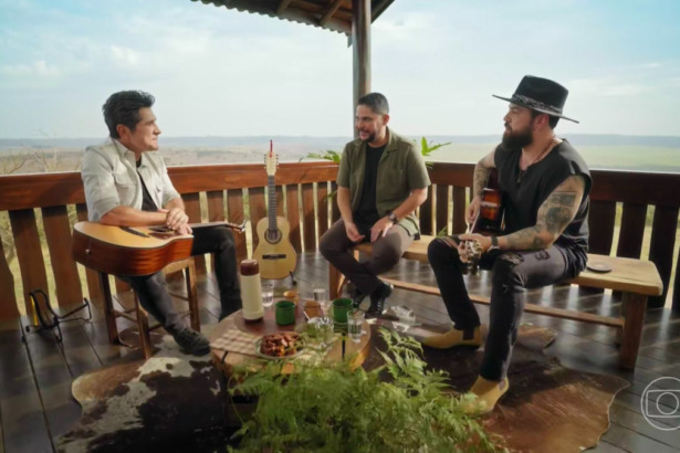 Daniel olha para Jorge & Mateus sentados na varanda de uma Fazenda