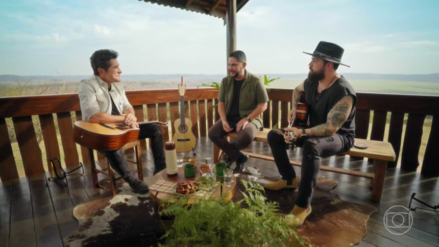 Daniel olha para Jorge & Mateus sentados na varanda de uma Fazenda