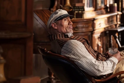 Dwayne Johnson sentado em uma cadeira em cena de Jungle Cruise