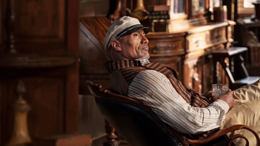 Dwayne Johnson sentado em uma cadeira em cena de Jungle Cruise