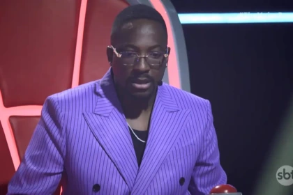 Mumuzinho de terno lilás com olhar assustado na estreia do The Voice Brasil no SBT