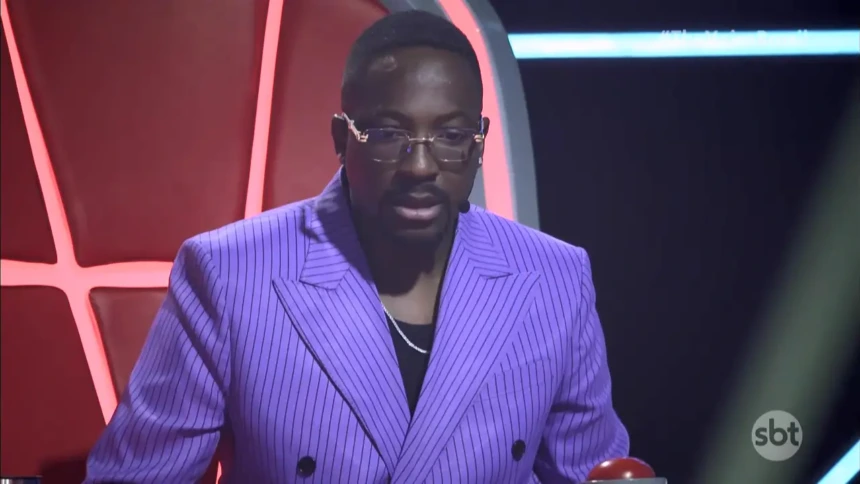 Mumuzinho de terno lilás com olhar assustado na estreia do The Voice Brasil no SBT