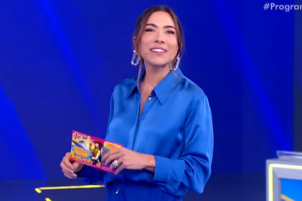 A apresentadora Patricia Abravanel usa uma blusa azul e segura uma Tele Sena na mão, em trecho do terceiro sorteio