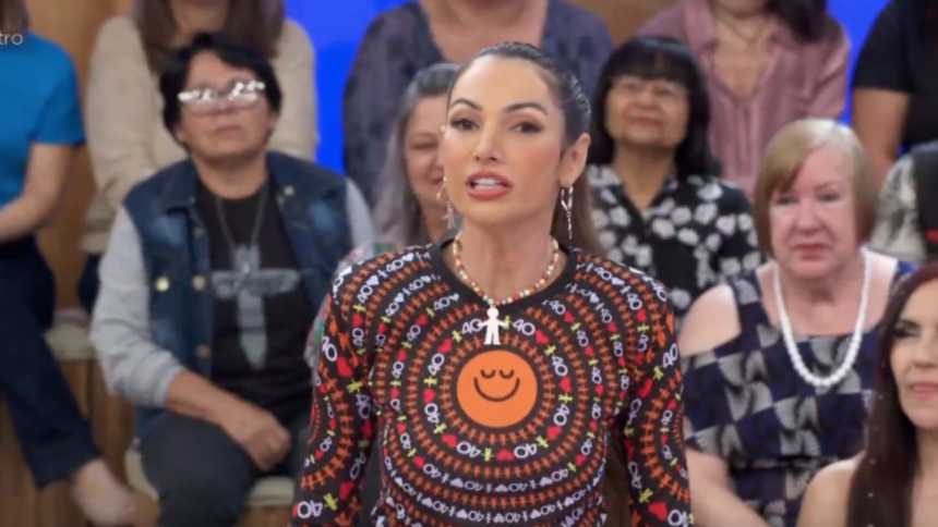 Patrícia Poeta vestida com a blusa do Criança Esperança em frente a plateia no palco do Encontro
