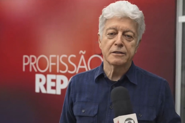 Caco Barcellos, em trecho do Profissão Repórter gravado na rua. Ele segura o microfone com a logo da emissora.