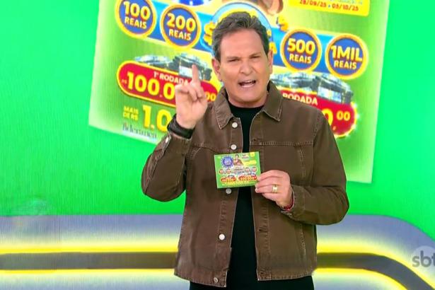 Luis Ricardo no estúdio temático na cor verde apresentando a edição 72 da Tele Sena Semanal. Ele segura o bilhete da edição