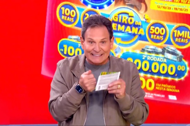 Luis Ricardo no centro do cenário da Tele Sena Semanal edição 74. O cenário está na cor vermelha