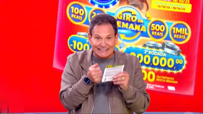 Luis Ricardo no centro do cenário da Tele Sena Semanal edição 74. O cenário está na cor vermelha
