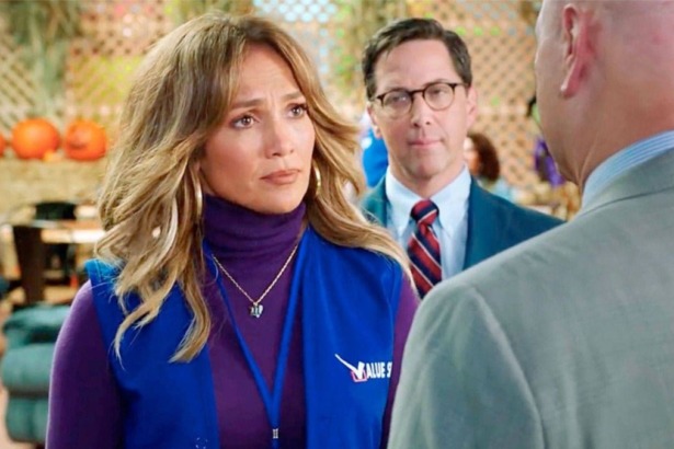 Cena do filme Uma Nova Chance. Jennifer Lopez usa um colete de trabalho azul e blusa roxa, olhando com expressão séria.