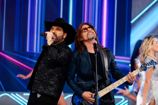 Edson & Hudson lado a lado cantando no palco do Domingo Legal
