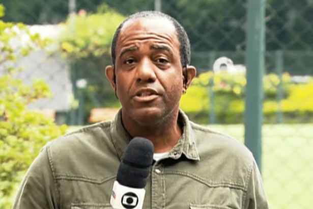 Abel Neto segurando o microfone da Globo em trecho de reportagem