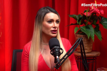 Andressa Urach em entrevista no podcast Sem Filtro, falando no microfone em estúdio com fundo vermelho