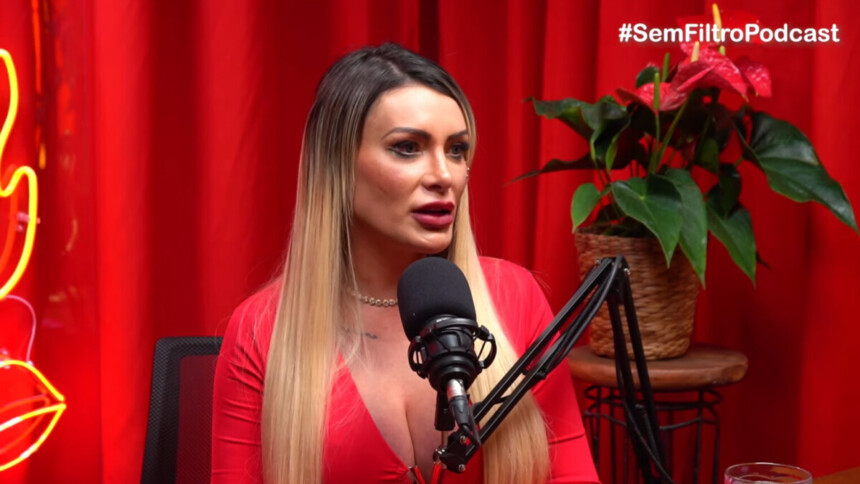 Andressa Urach em entrevista no podcast Sem Filtro, falando no microfone em estúdio com fundo vermelho