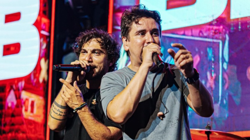 Dupla sertaneja Bruninho e Davi performando em show com cenário de luzes e grande público