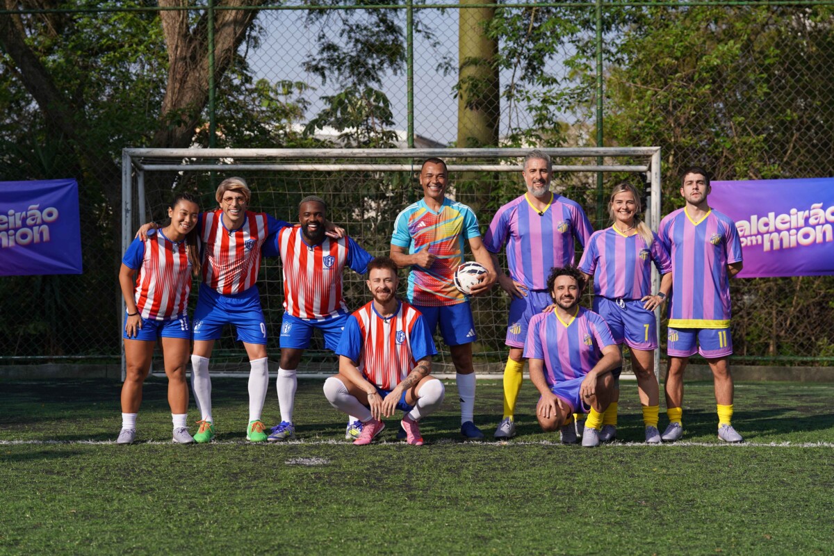 Mion e equipe de esportes da Globo em um campo de futebol vestidos com uniforme de time do Caldeirão
