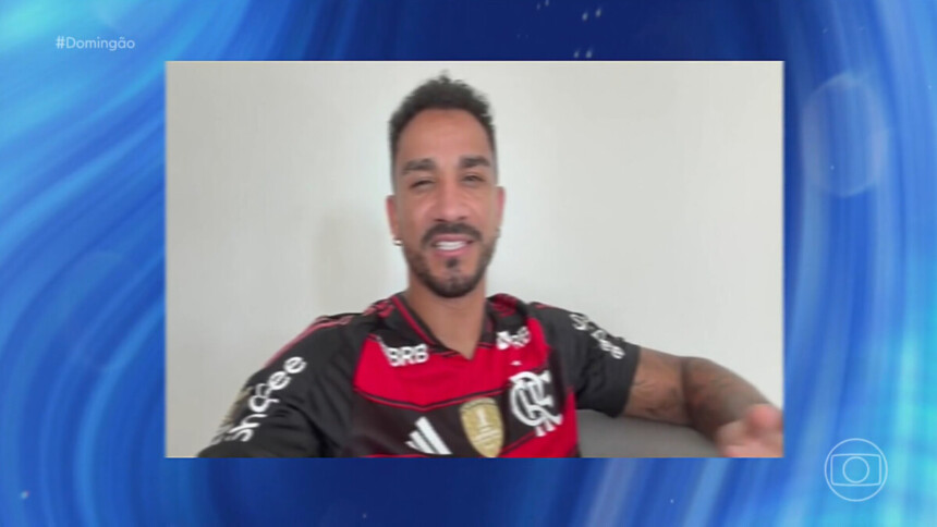 Jogador de futebol Danilo, vestindo a camisa do Flamengo, sorrindo durante entrevista remota para o programa Domingão com Huck