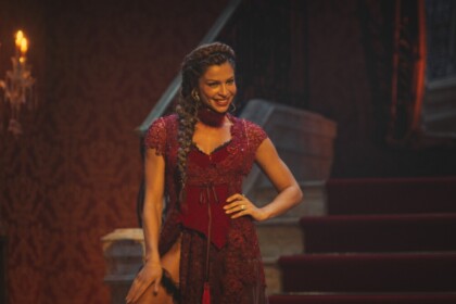 Ana Jacinta de São José (Dona Beja) de vestido vermelho em cena da novela da HBO