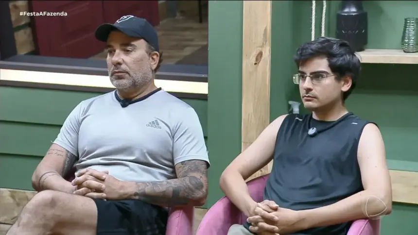 Fabiano sentado ao lado de Dudu Camargo conversando com o diretor de A Fazenda na academia do reality show