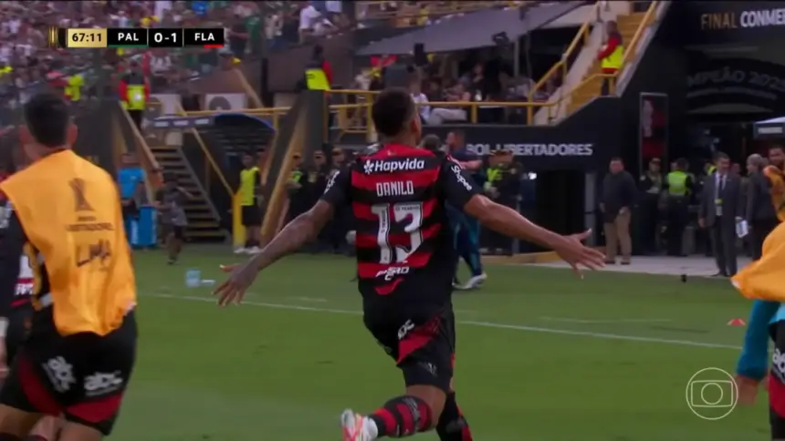 Danilo corre no meio do campo com os braços abertos comemorando o Gol da vitória do Flamengo na Libertadores