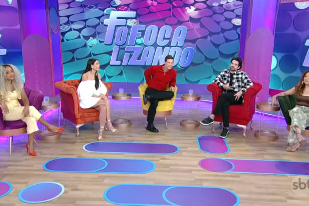 Apresentadores do Fofocalizando no SBT sentados em suas poltronas num cenário com cores predominantemente em tons de lilás e azul