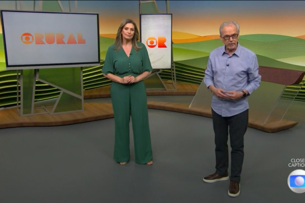 Cristina Vieira de vestido verde ao lado de Nélson Araújo que veste camisa clara e calça preta no cenário do Globo Rural