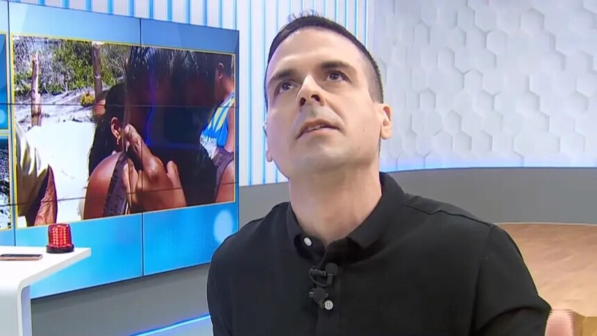 Marcelo Castro, Juca, olha para o teto e faz oração no cenário do Alô Juca. Ao fundo um telão com uma mulher chorando