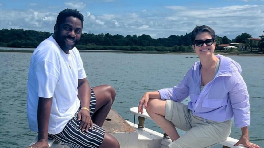 Ator Lázaro Ramos e jornalista Sandra Annenberg sorrindo em um barco, durante gravação externa para o programa Globo Repórter