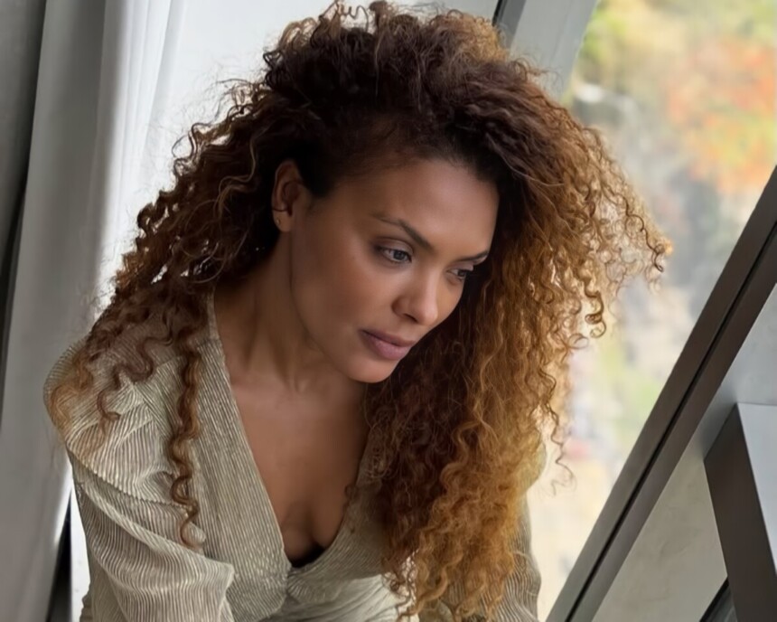 Lidi Lisboa sentada em uma janela