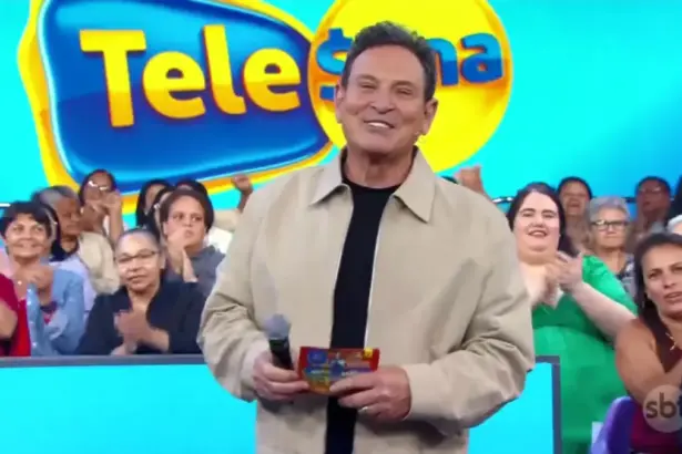 Luís Ricardo sorridente apresentando o sorteio da Tele Sena Semanal 79. Ele está em pé em frente a plateia