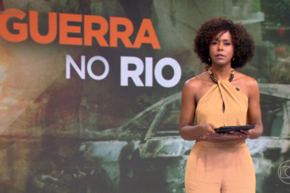 Maju Coutinho em pé no cenário, em trecho de edição do Fantástico, com o letreiro "Guerra no Rio" exposto no telão