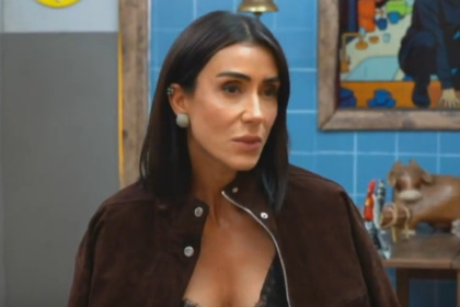 Jornalista Michelle Barros ex-peoa de A Fazenda 17 na Live do Eliminado, vestindo jaqueta de camurça em estúdio com decoração rústica