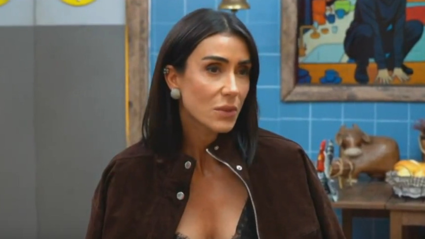 Jornalista Michelle Barros ex-peoa de A Fazenda 17 na Live do Eliminado, vestindo jaqueta de camurça em estúdio com decoração rústica