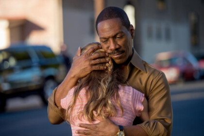 Eddie Murphy como Mr. Church abraçando uma garotinha em cena do filme