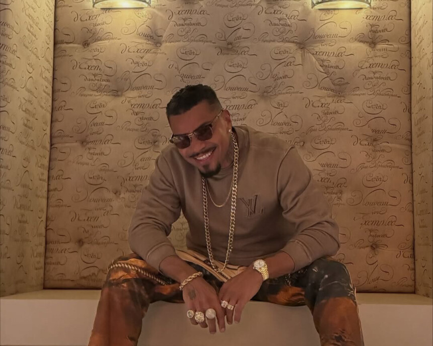 Naldo Benny sentado em um lugar bem luxuoso. Ele está de óculos escuro
