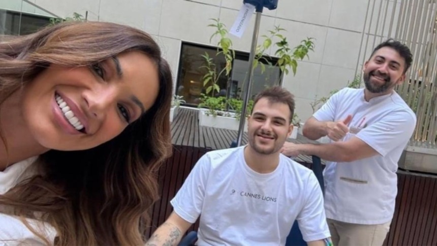 Patrícia Poeta sorridente ao lado do filho Felipe Poeta e de um enfermeiro