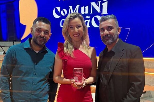 Foto de repórter recebendo o prêmio