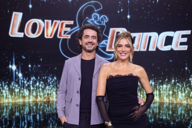 Apresentadores Rafa Brites e Felipe Andreoli posando juntos no cenário do programa Love & Dance, com fundo de estrelas e logo neon
