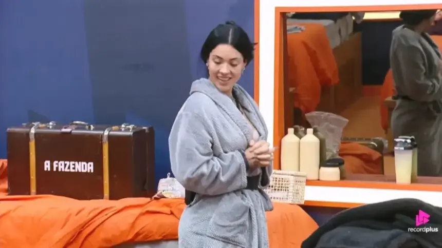 Rayane sorrindo e olhando para a mala ao lado da cama no quarto de A Fazenda 17 após presentear Yoná