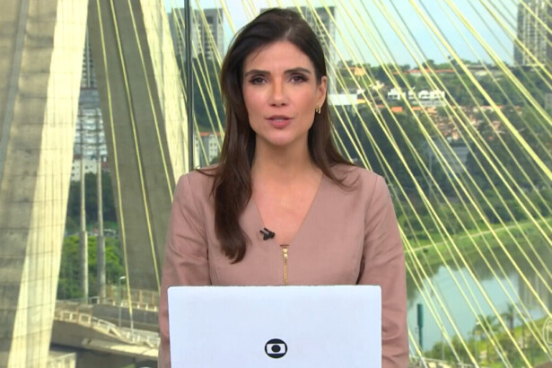 Jornalista Sabina Simonato apresentando o telejornal Bom Dia Brasil, com a Ponte Estaiada de São Paulo ao fundo e laptop à frente